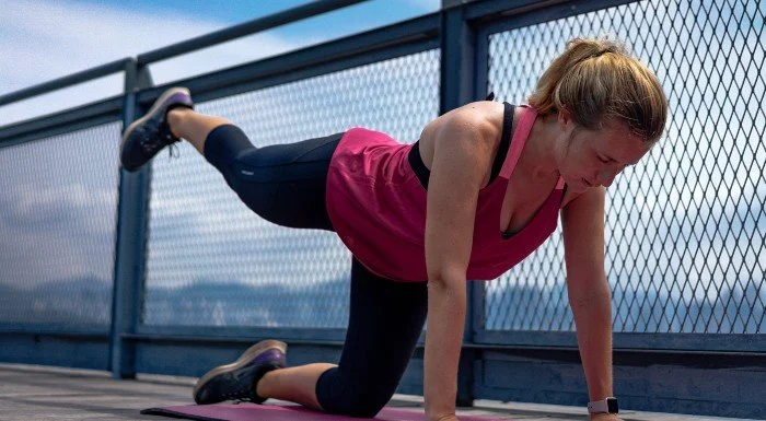 woman stretching outside on bridge